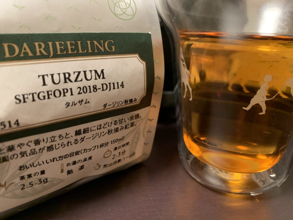 紅茶の茶葉「TURZUM」のパッケージとグラスに注がれた紅茶の写真。FTGFOPなどの等級に関する説明を示すイメージ。