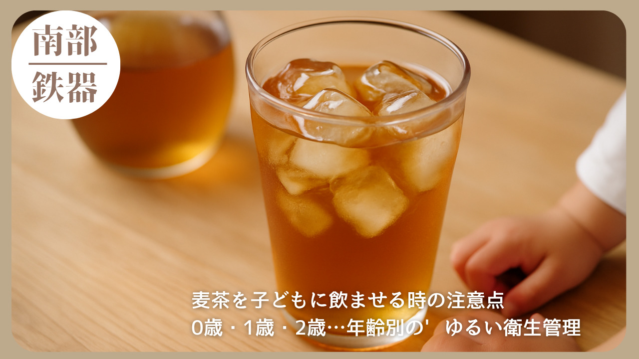 氷入りの麦茶が入ったグラスと、それに手を伸ばす小さな子どもの手元。年齢に応じた麦茶の衛生管理と飲用の注意点を扱った記事のアイキャッチ画像。