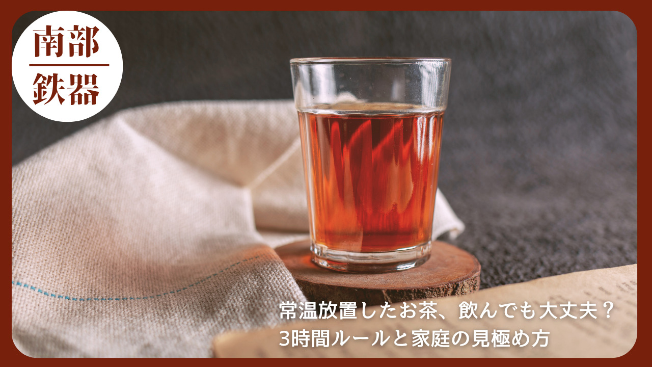 茶色い飲み物が入ったガラスコップが木のコースターの上に置かれ、背景には布とグレーの壁が見える落ち着いた雰囲気の写真。常温放置したお茶の衛生的な扱いに関する記事のアイキャッチ画像。