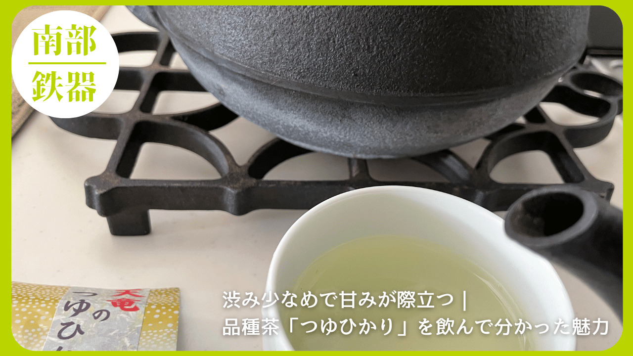 南部鉄瓶をコンロにかけ、白い湯呑みに注がれたつゆひかりの緑茶と茶葉パッケージが写る写真に、「渋み少なめで甘みが際立つ｜品種茶つゆひかりの魅力」というテキストを重ねたアイキャッチ画像